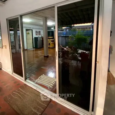 Spacious living area with sliding glass doors opening to a cozy outdoor patio, perfect for relaxation.