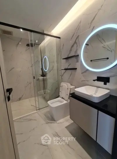 Luxurious modern bathroom with marble tiles and illuminated mirror