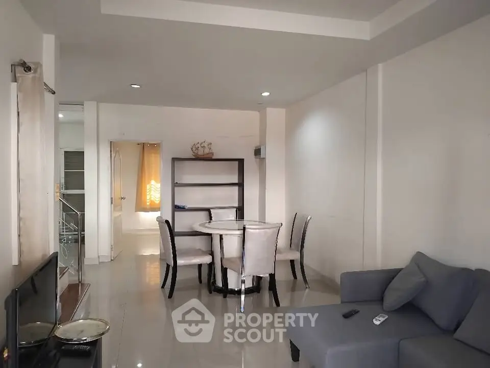 Spacious living room with modern furniture and dining area in a cozy apartment.