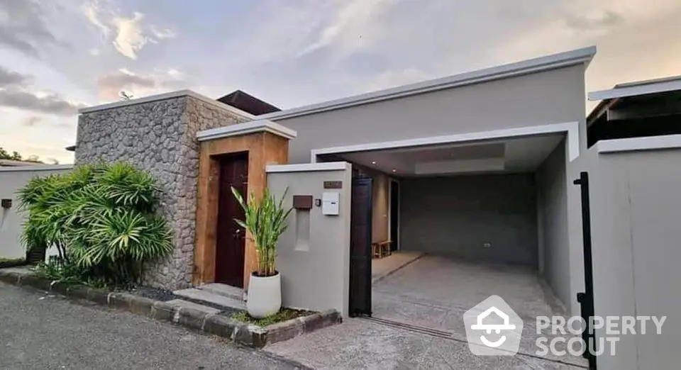 Modern minimalist house exterior with stone accent wall and lush greenery