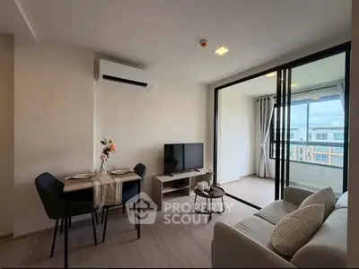 Modern living room with balcony view, featuring sleek furniture and natural light.