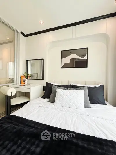 Modern bedroom with stylish decor and cozy bedding in a contemporary apartment.