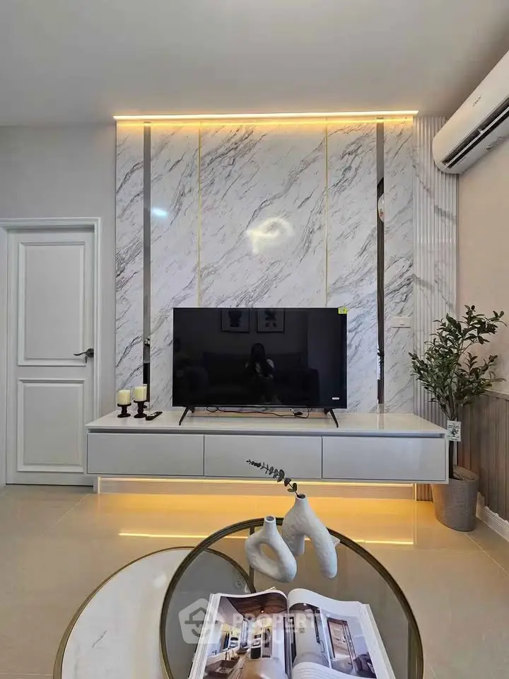 Modern living room with sleek TV unit, marble accent wall, and ambient lighting.