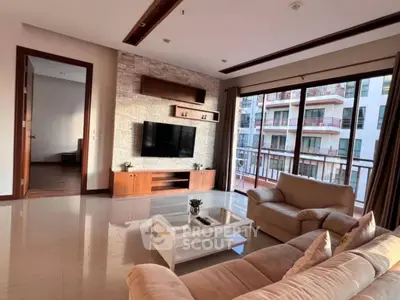 Spacious living room with modern decor and large windows offering a stunning view of the cityscape.