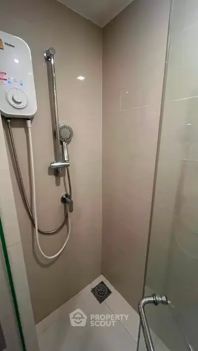 Modern bathroom with sleek shower and water heater in a compact space.