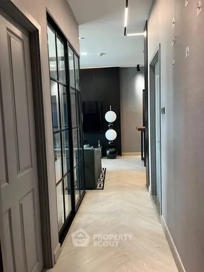Stylish modern hallway leading to a chic living room with elegant decor and sleek flooring.
