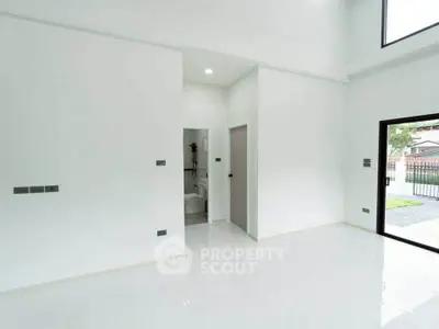 Spacious modern interior with high ceilings and large windows, offering abundant natural light and a sleek design.