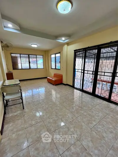 Spacious living room with tiled floors and large windows for natural light