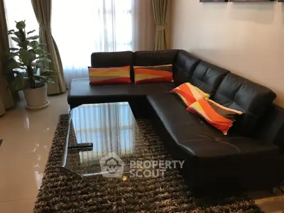Stylish living room with modern leather sofa and glass coffee table, perfect for relaxation.