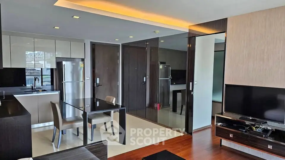 Modern open-layout kitchen and living area with sleek design and natural light.