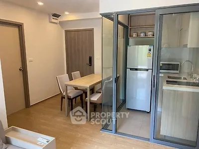 Modern apartment with compact kitchen and dining area, featuring sleek design and efficient use of space.