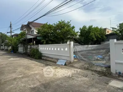 Charming suburban house with lush greenery and secure fencing in a peaceful neighborhood.