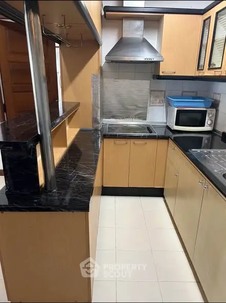 Modern kitchen with sleek black countertops and wooden cabinets