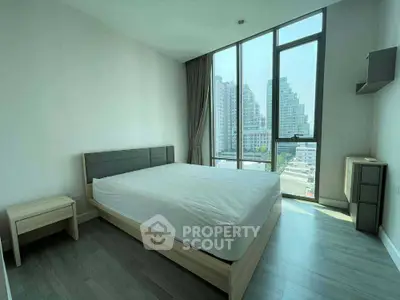 Modern bedroom with large windows and city view in a high-rise apartment