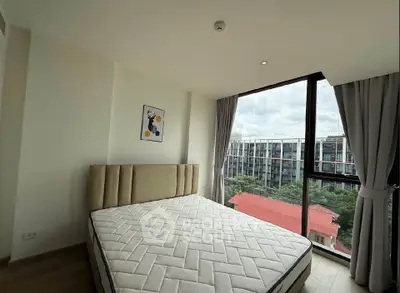 Modern bedroom with large window offering stunning city view, featuring a stylish bed and elegant decor.