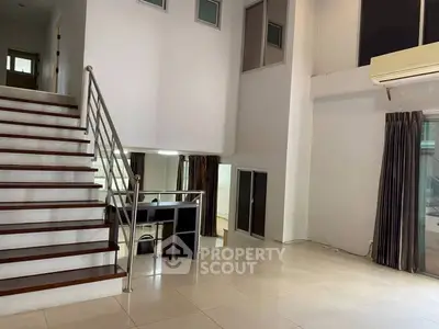 Spacious modern living room with high ceilings and elegant staircase