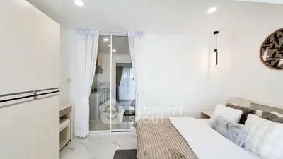 Modern bedroom with cozy decor and sliding glass door to kitchen