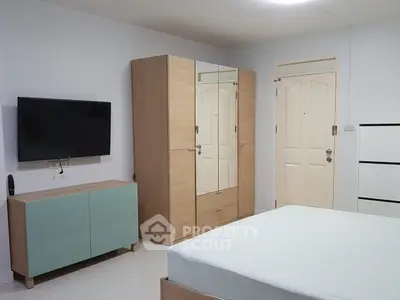 Modern bedroom with minimalist furniture and wall-mounted TV