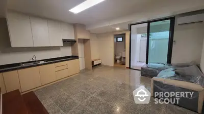 Spacious modern living room with open kitchen and large sliding doors to patio.