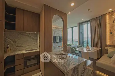 Luxurious modern kitchen with marble countertops and open layout to stylish living area.