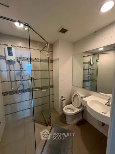 Modern bathroom with glass shower and sleek fixtures in a contemporary home.