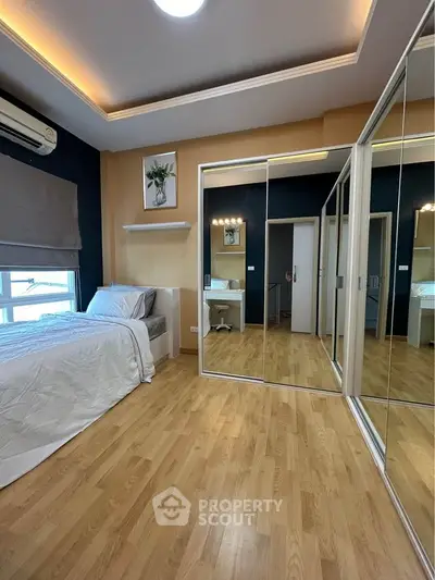 Spacious bedroom with mirrored closet and modern decor
