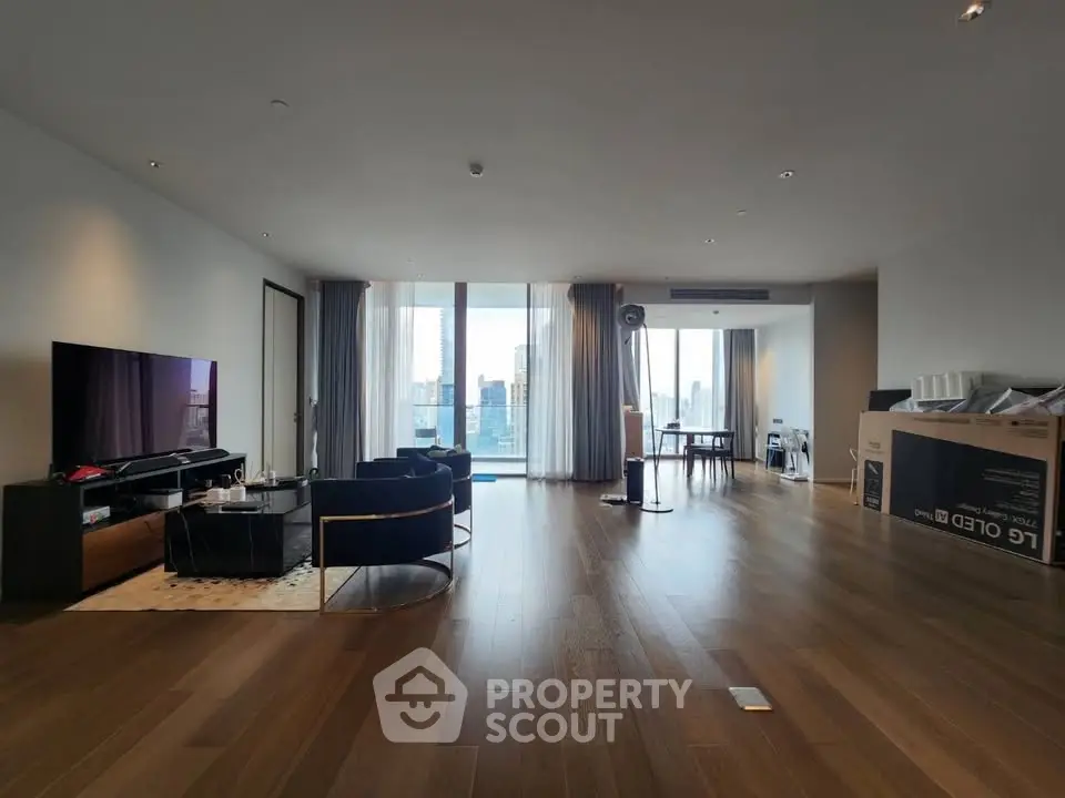 Spacious modern living room with floor-to-ceiling windows and city view