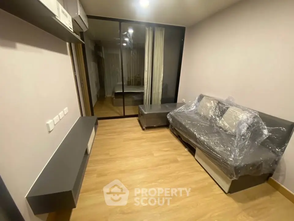 Modern living room with sleek furniture and wooden flooring in a stylish apartment.