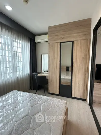 Modern bedroom with stylish wardrobe and natural light through large windows.