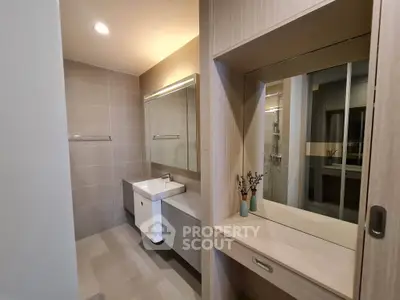 Modern bathroom with sleek vanity and large mirror in a stylish apartment.