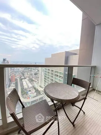 Stunning high-rise balcony with panoramic city views and cozy seating area.