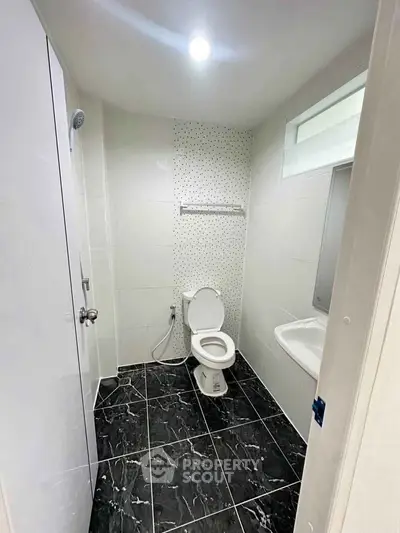 Modern bathroom with sleek black and white tiles and contemporary fixtures.