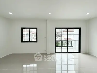 Spacious modern living room with large windows and glossy tiled floor