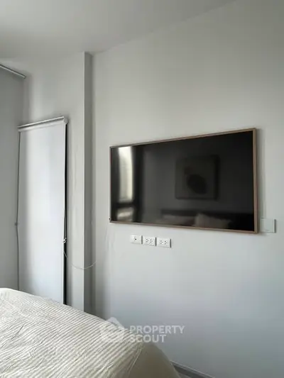 Modern bedroom with wall-mounted TV and minimalist decor