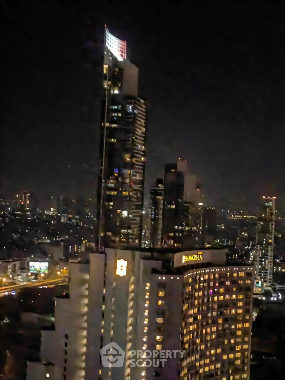 Stunning night view of illuminated skyscrapers in a bustling cityscape, showcasing urban luxury living.