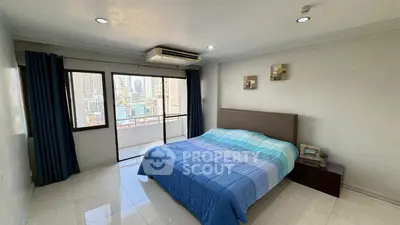 Spacious bedroom with city view and balcony access in modern apartment