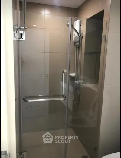Modern bathroom with glass shower enclosure and sleek fixtures.