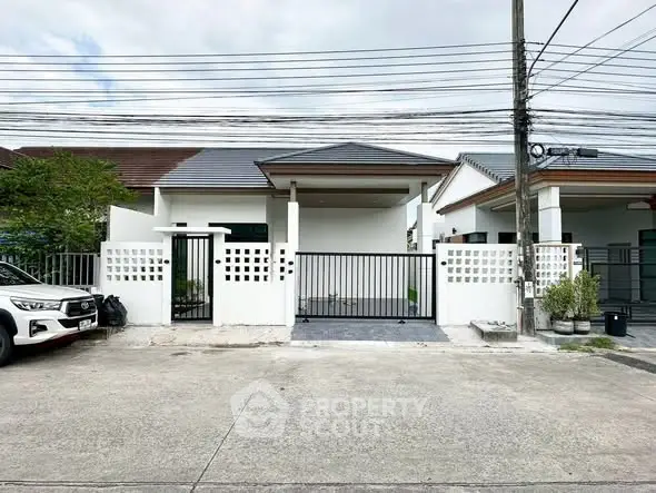 Charming single-story home with modern design and gated entrance in a suburban neighborhood.