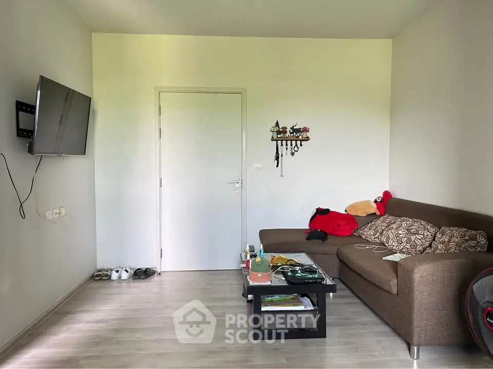 Cozy living room with modern sofa and wall-mounted TV, perfect for relaxation.