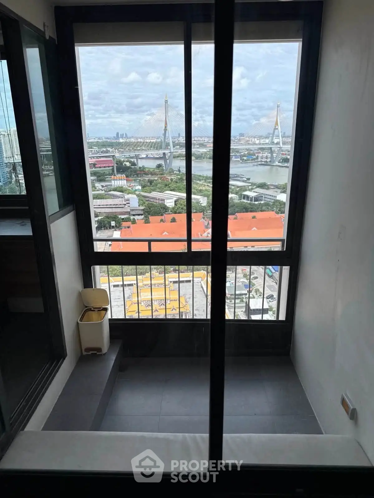 Stunning high-rise balcony view with river and bridge panorama, perfect for urban living enthusiasts.