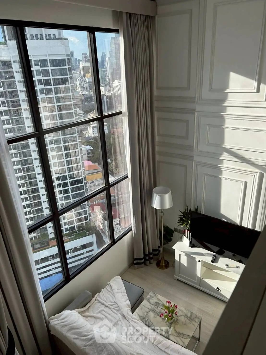 Stunning high-rise living room with floor-to-ceiling windows offering breathtaking city views.