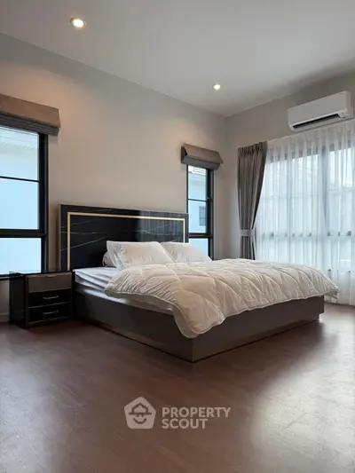 Spacious modern bedroom with large windows and elegant decor