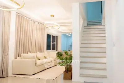 Modern living room with elegant staircase and cozy seating area