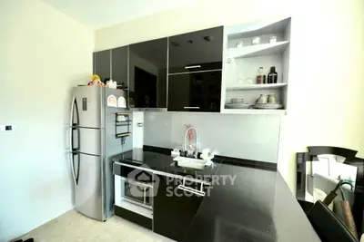 Modern kitchen with sleek black cabinets and stainless steel appliances