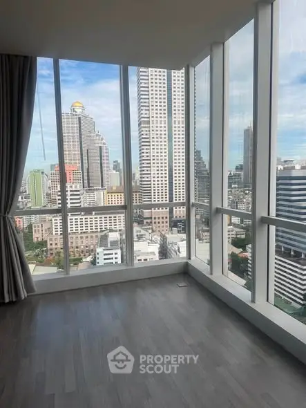 Spacious corner unit with floor-to-ceiling windows offering stunning city views in a modern high-rise building.