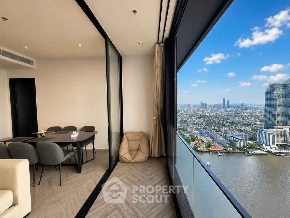 Stunning high-rise apartment with panoramic city and river views, featuring a modern dining area and floor-to-ceiling windows.