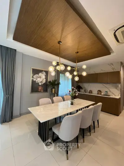Luxurious dining room with elegant chandelier and modern kitchen in open layout