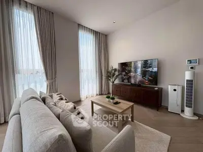 Elegant living room with modern decor, large windows, and stylish furniture for a cozy ambiance.