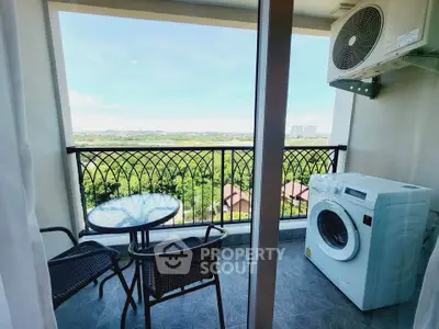 Charming balcony with scenic view, featuring outdoor seating and washing machine, perfect for relaxation.