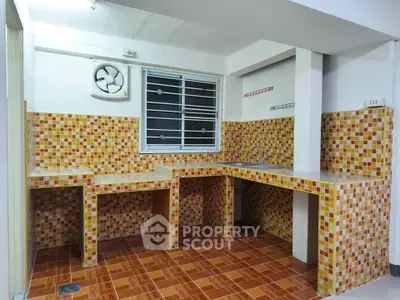 Charming kitchen with vibrant mosaic tiles and ample counter space, perfect for culinary enthusiasts.